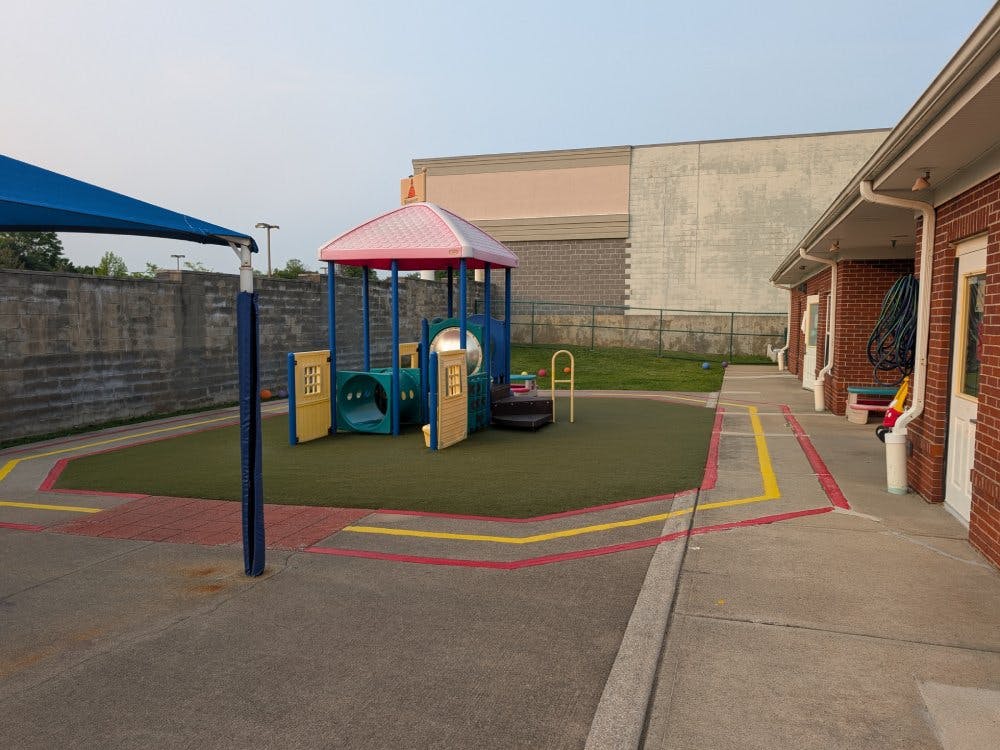 Playground with tunnels and a red roof structure on artificial grass