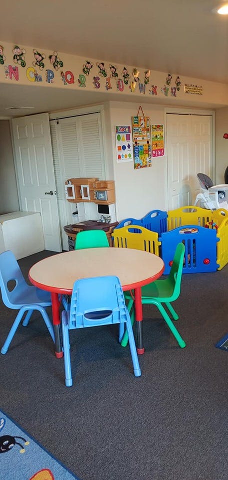 Children's play area with a round table and colorful chairs