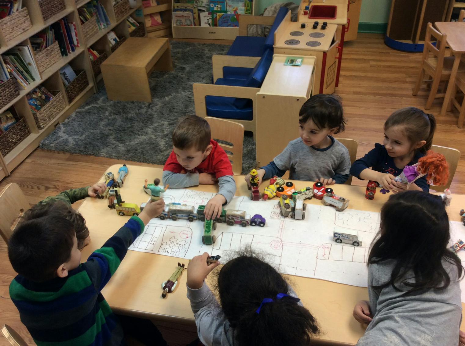 Children playing with toys at a table in a classroom