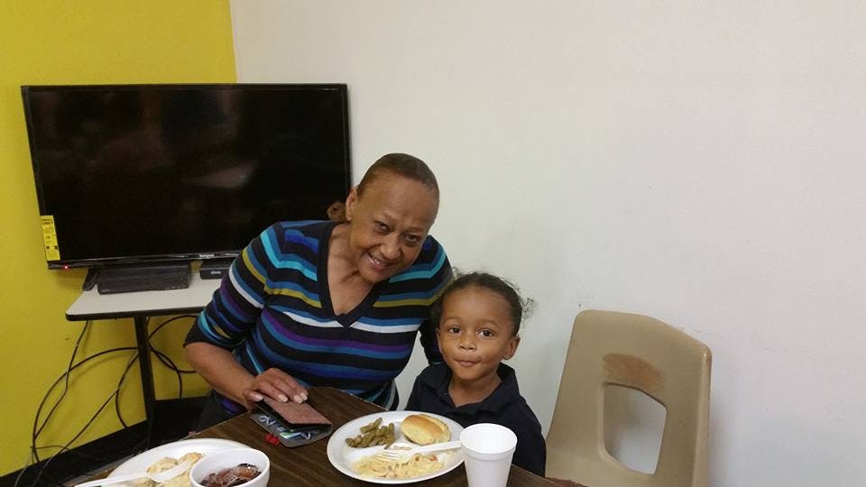 Person and child sitting at a table with plates of food