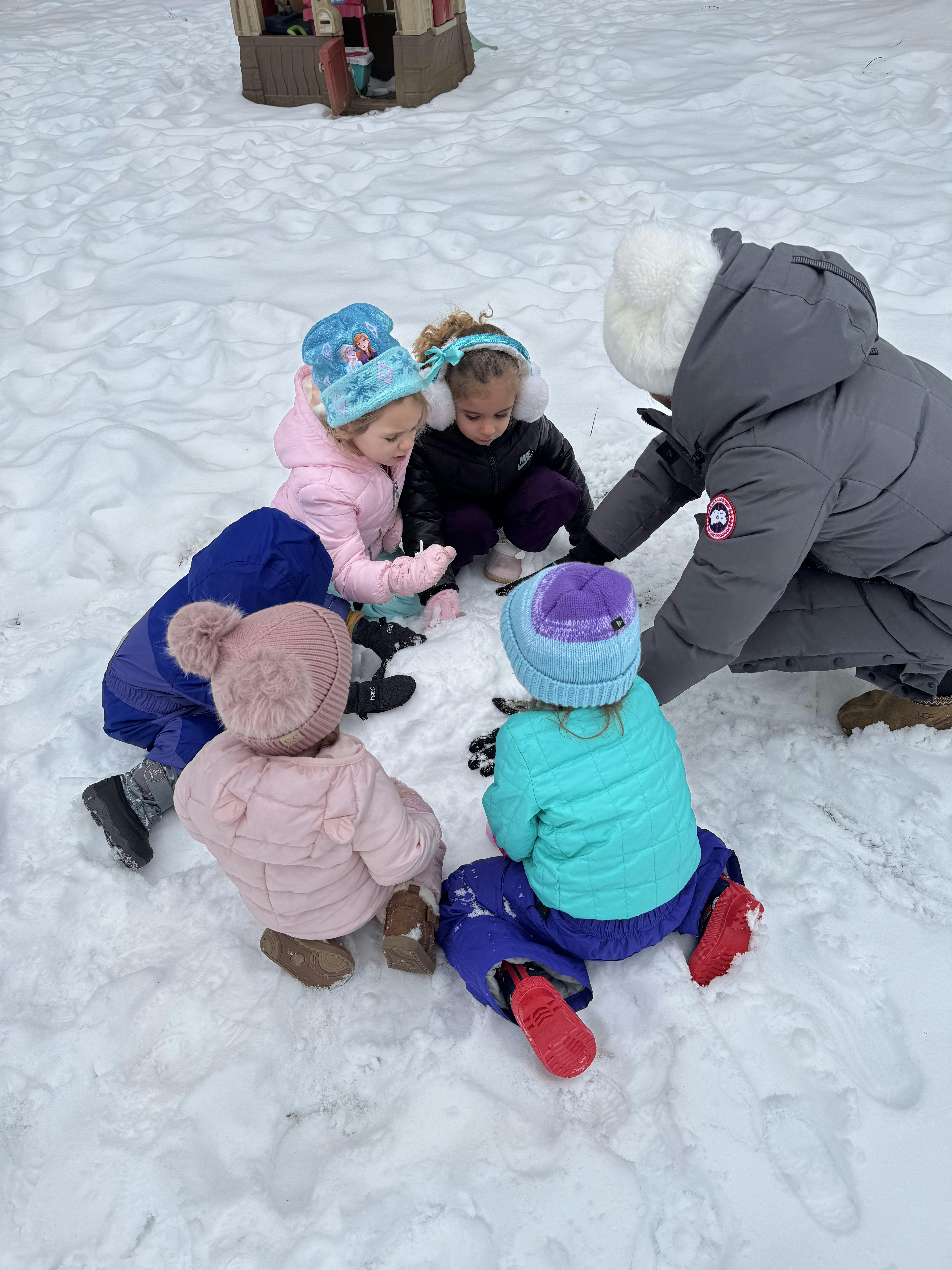 Adult and children playing in the snow
