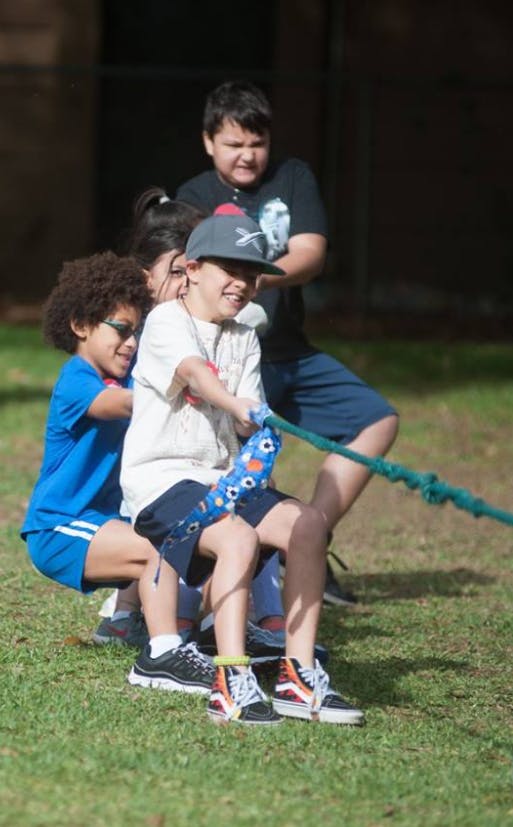 Children playing tug of war on grass