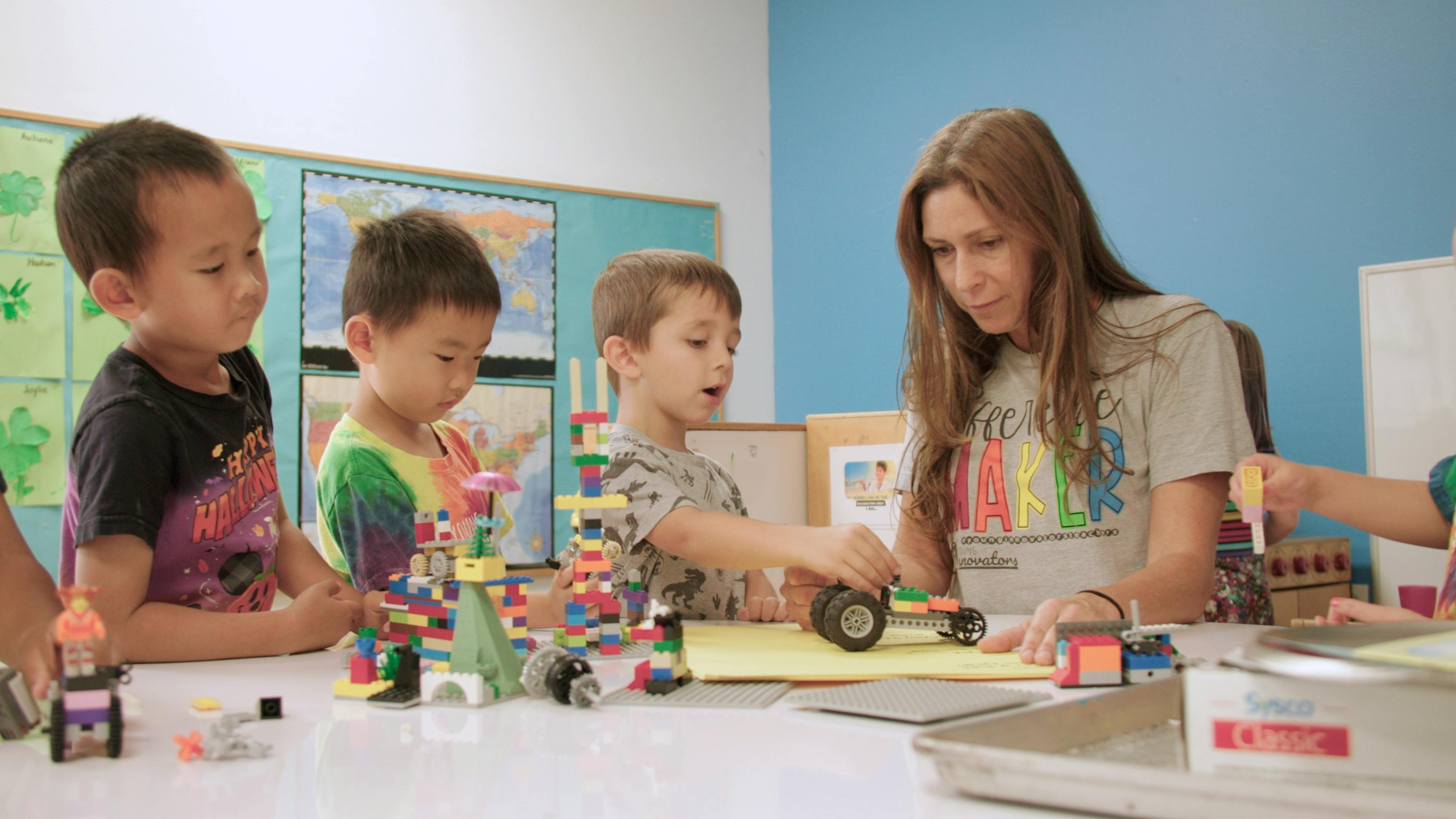 Adult and children playing with building blocks at a table