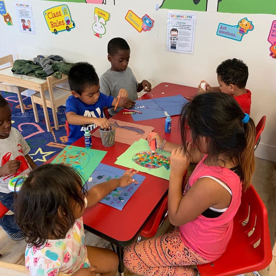 Children sitting at a table doing crafts