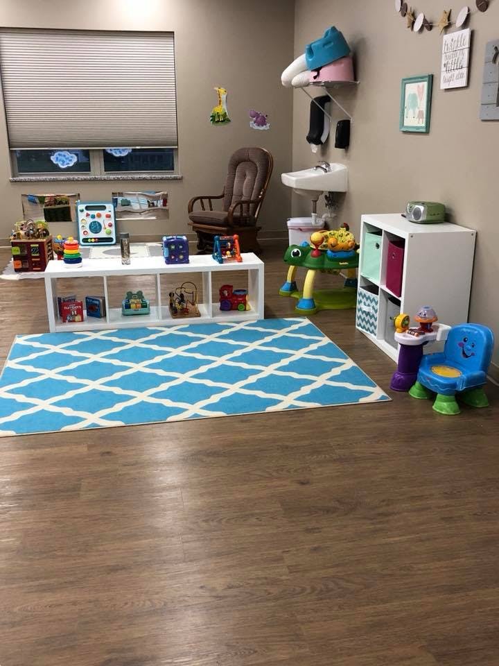 Children's play area with toys, a blue patterned rug, and small furniture