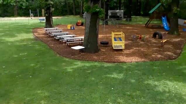 Playground with wood chips, slide, and benches