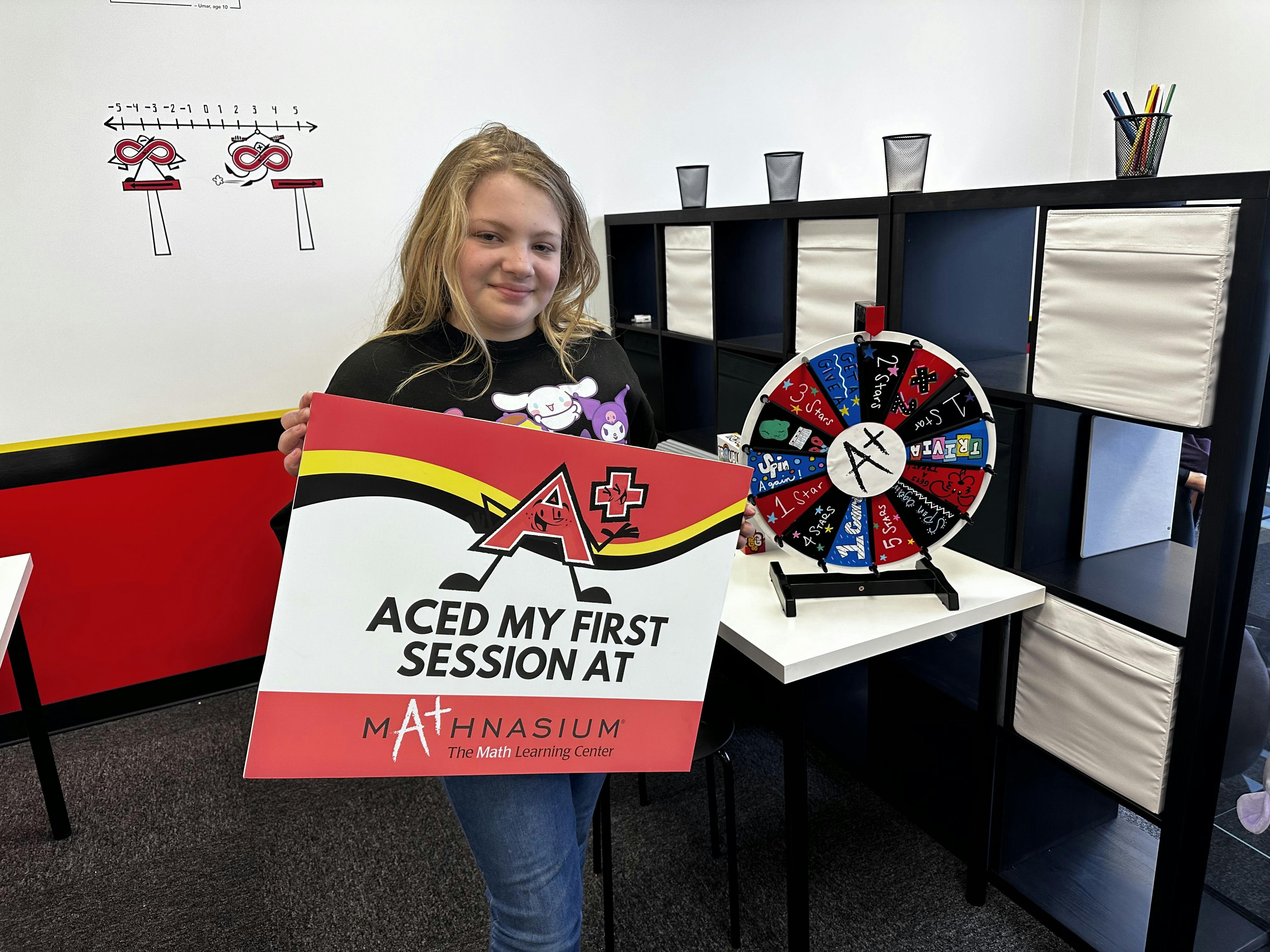 Teen holding a sign that says "Aced my first session at Mathnasium"