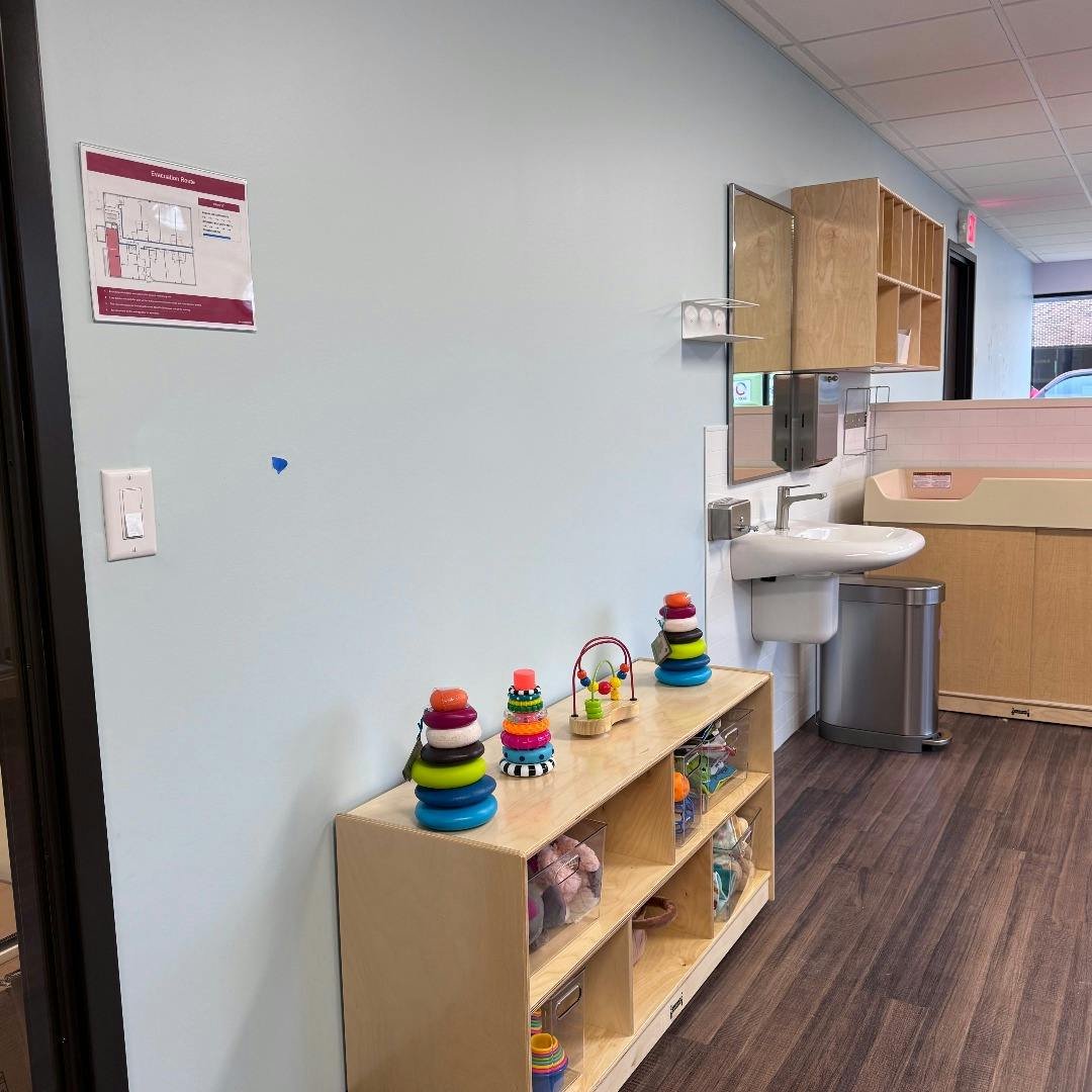 Classroom with toy shelves, child-sized sink, and baby changing station