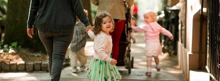 Person walking with two children holding hands