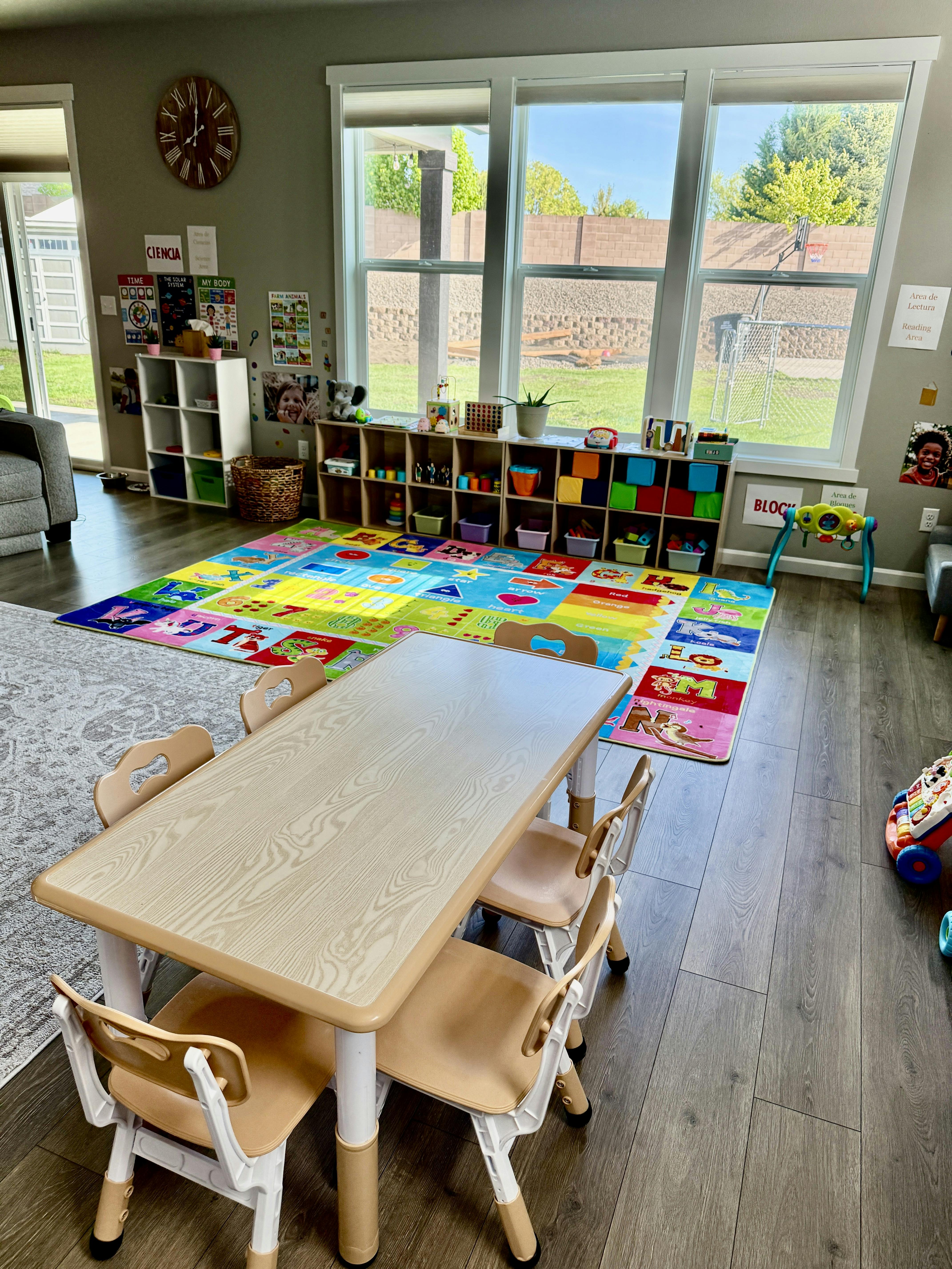 Playroom with a small table and chairs, colorful rug, and storage shelves