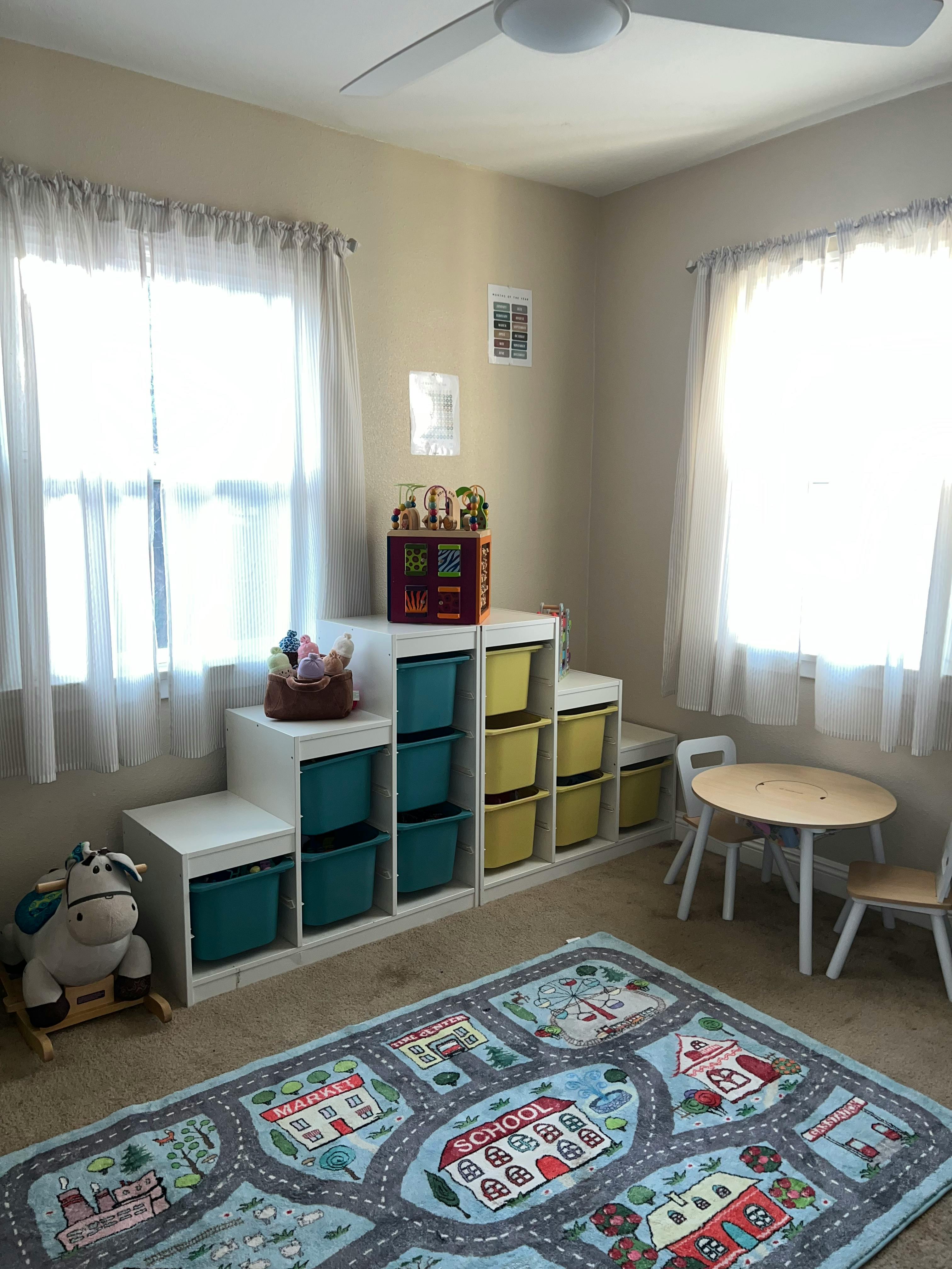 Playroom with toy storage, small table and chairs, and a road map rug