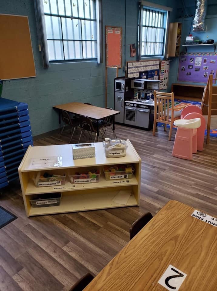 Classroom with tables, chairs, and a play kitchen