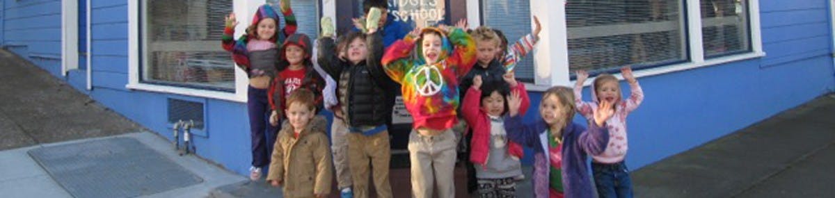 Group of children standing with arms raised