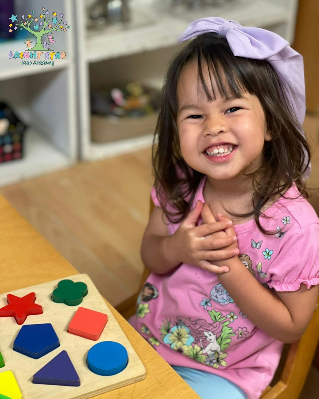 Child sitting at a table with a shape sorter puzzle