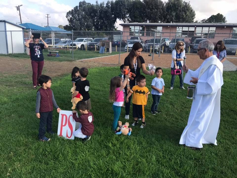 Adults and children gathered on a grassy field