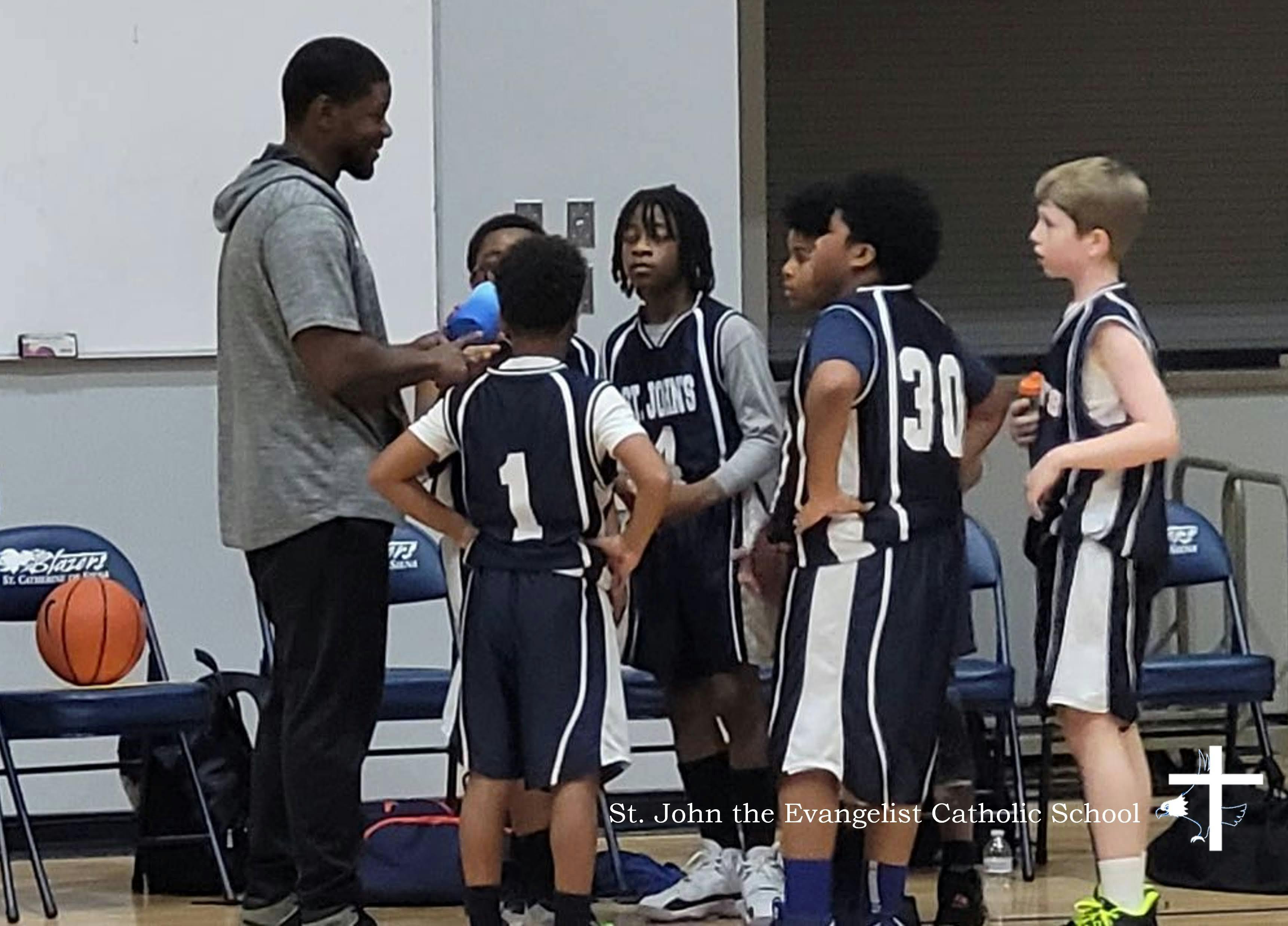 Adult and children in basketball uniforms standing together
