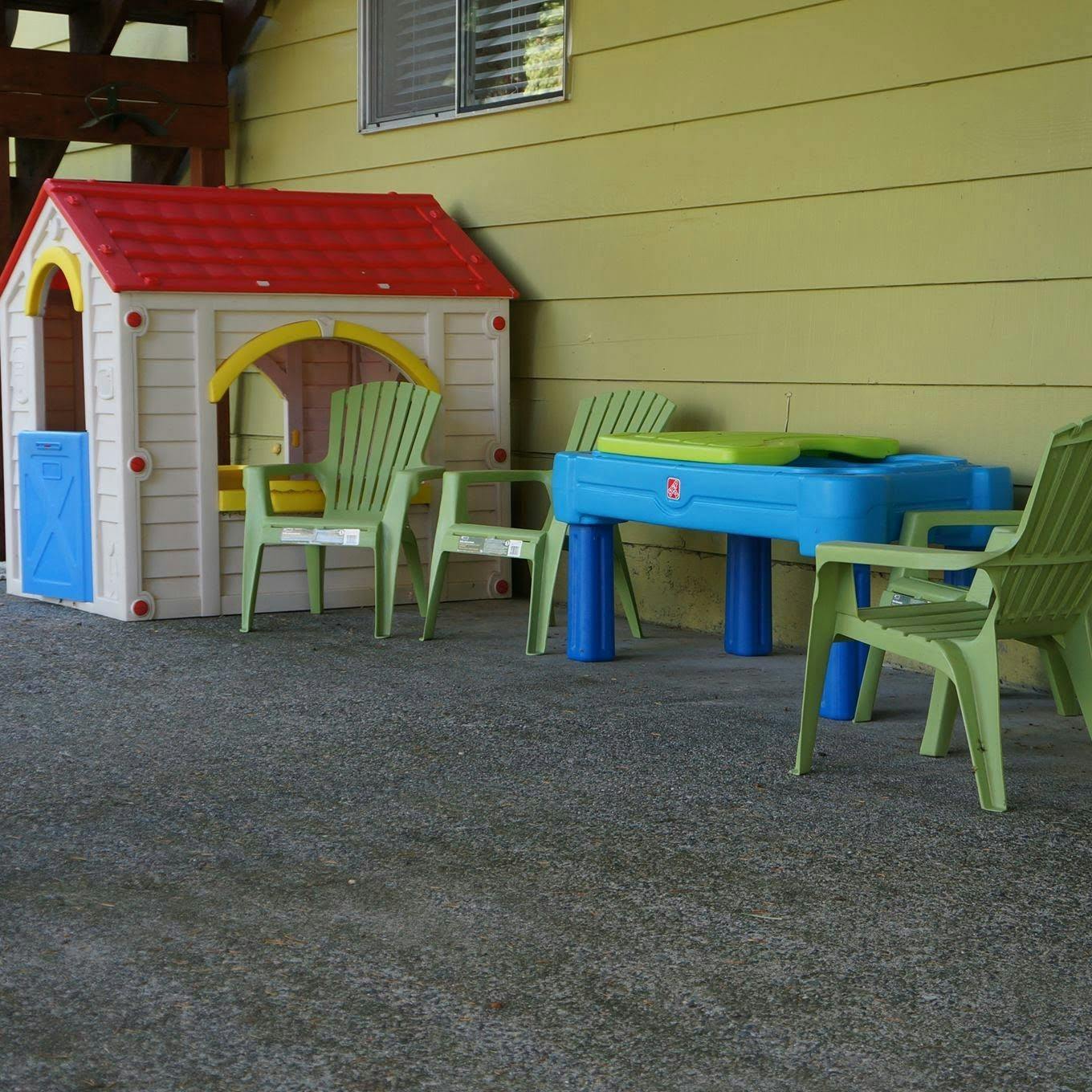 Plastic playhouse and table with chairs on a patio