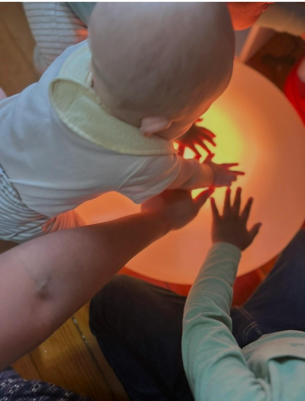 Child and person reaching for a glowing object