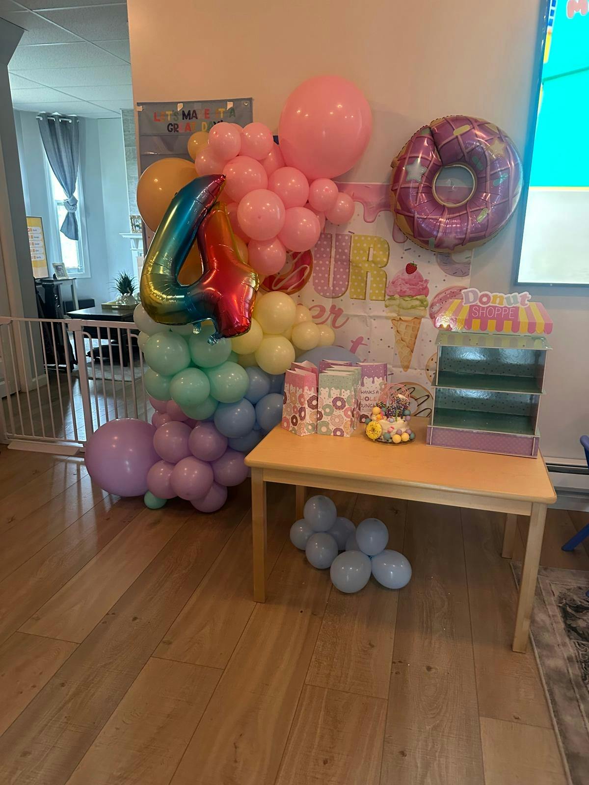 Birthday party decorations with number four balloon and donut theme display
