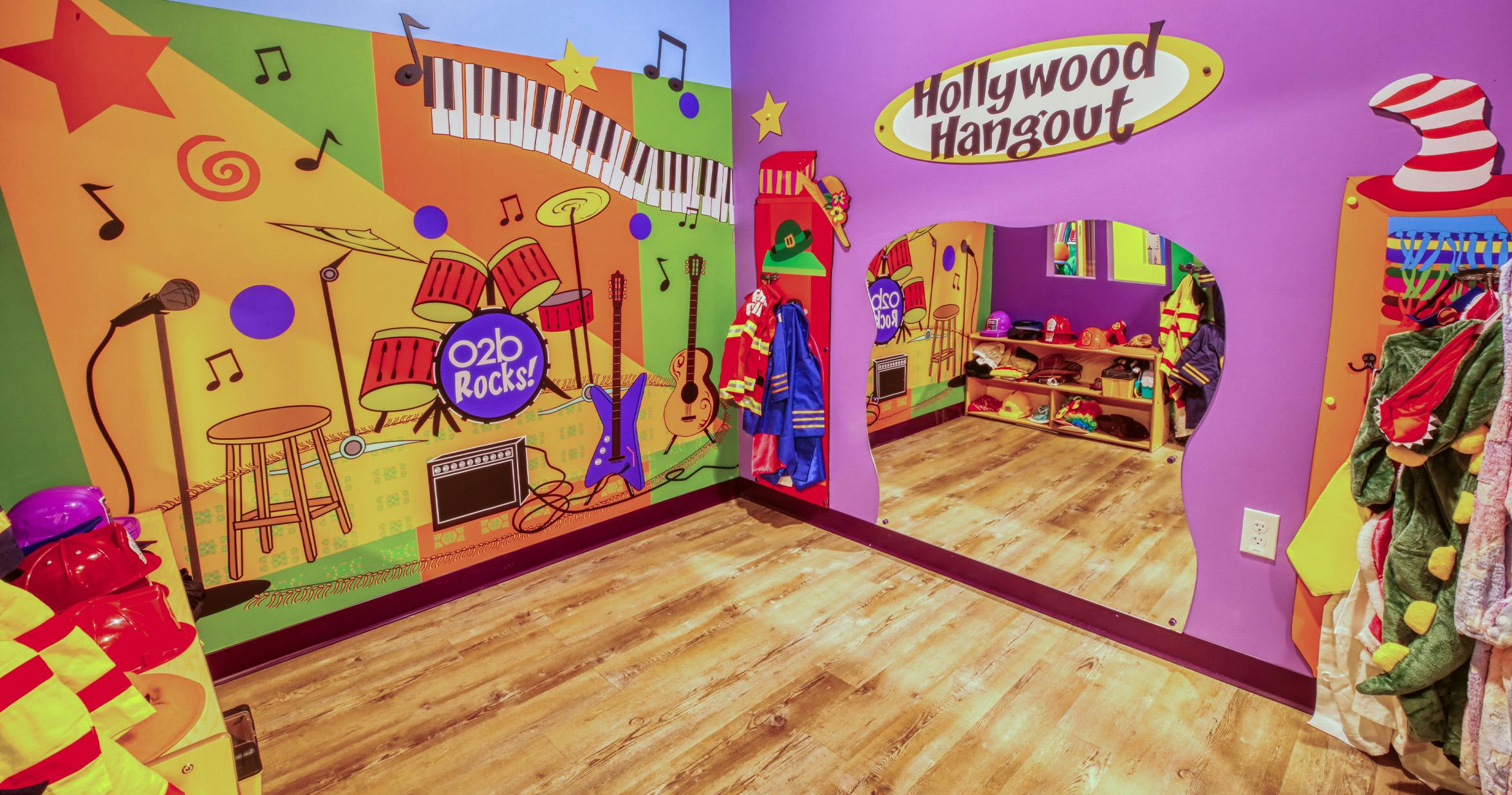 A colorful room with music-themed wall art and dress-up clothes