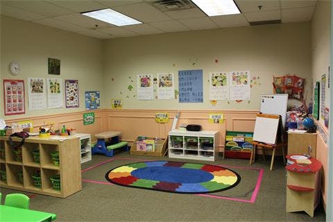 Empty classroom with colorful rug and learning materials