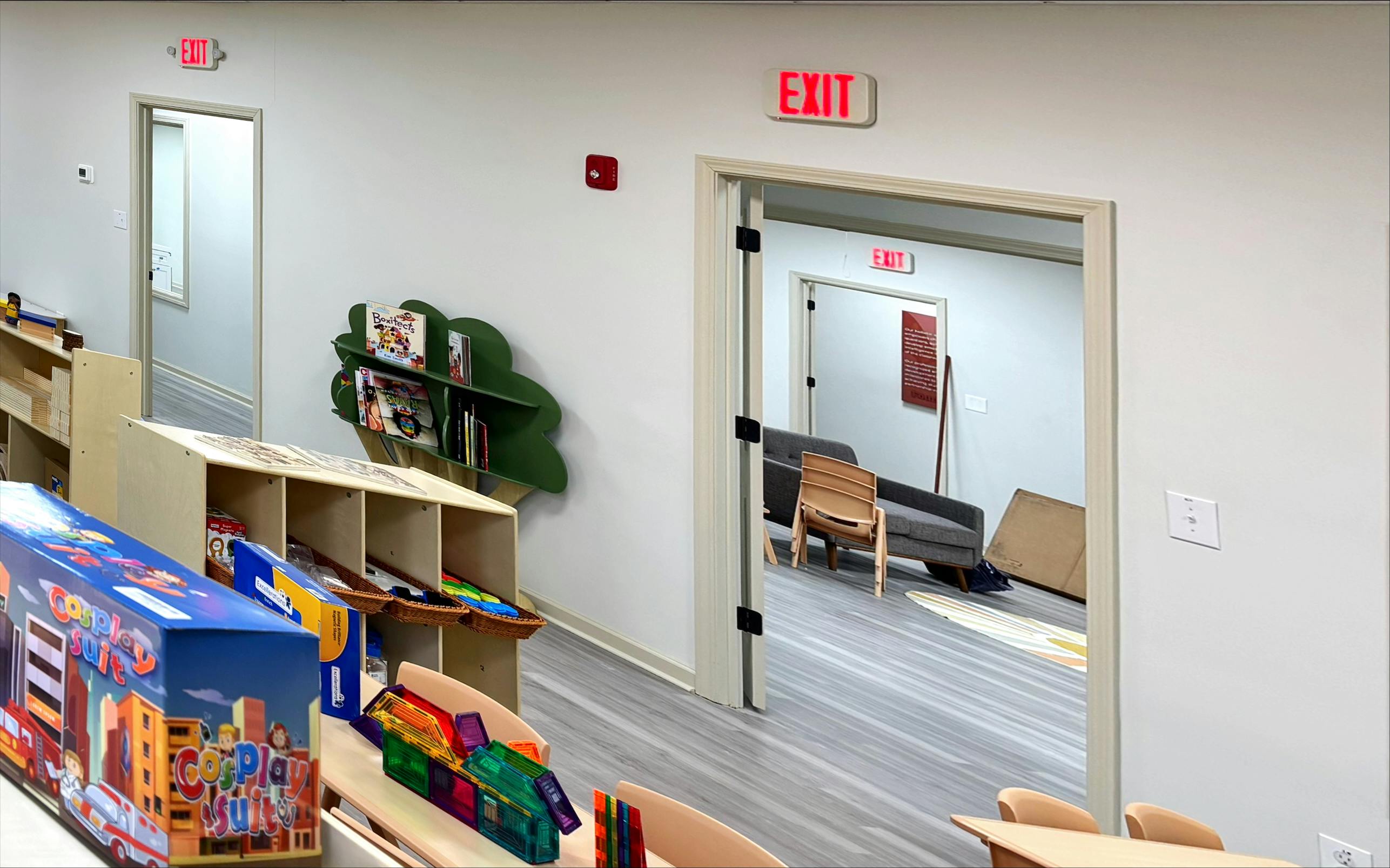 Classroom with child-sized furniture and a green tree-shaped bookshelf