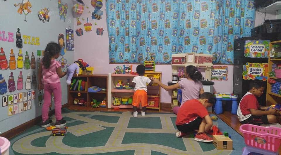 Adults and children playing with toys in a classroom