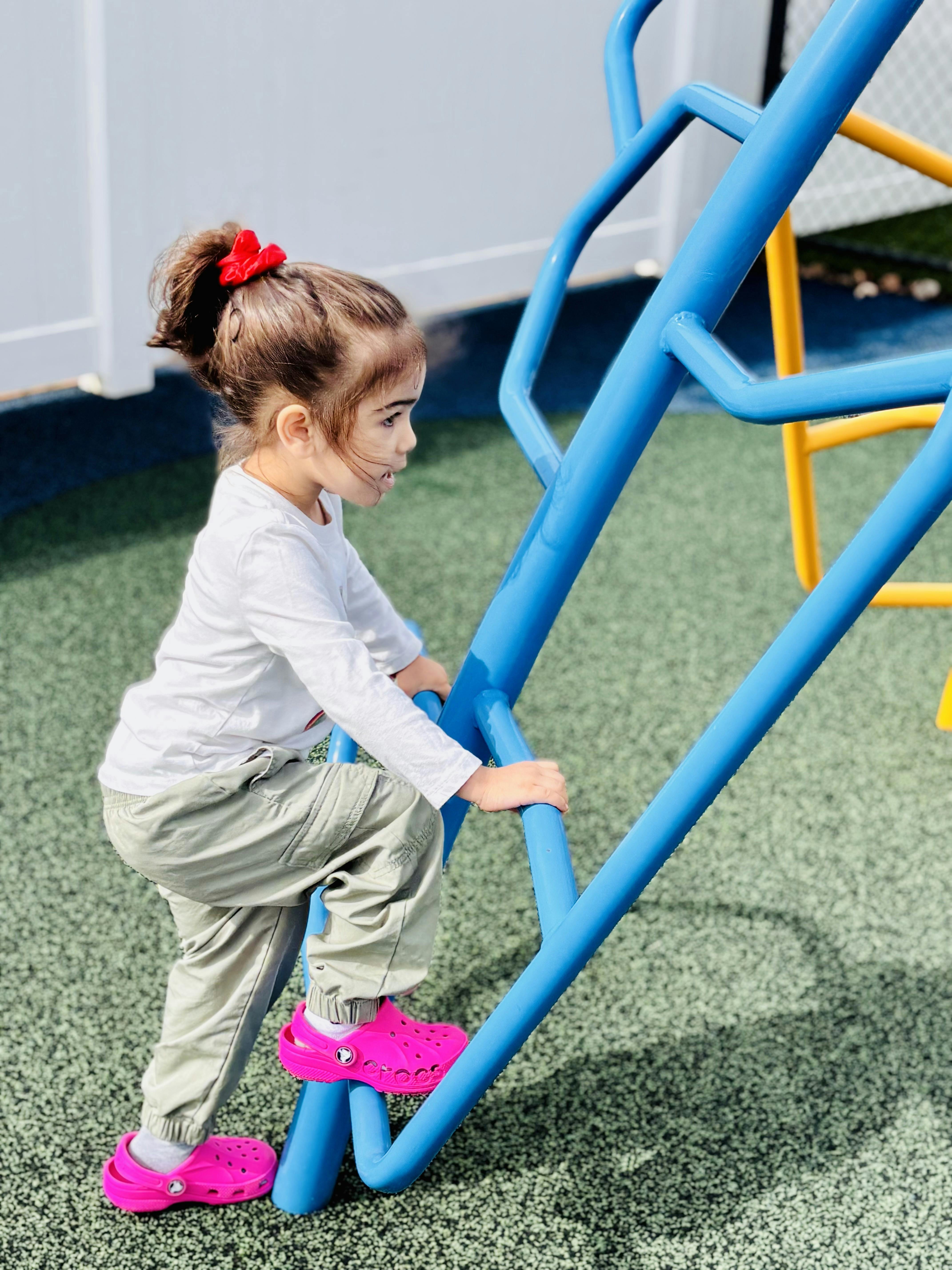 Child climbing blue playground equipment
