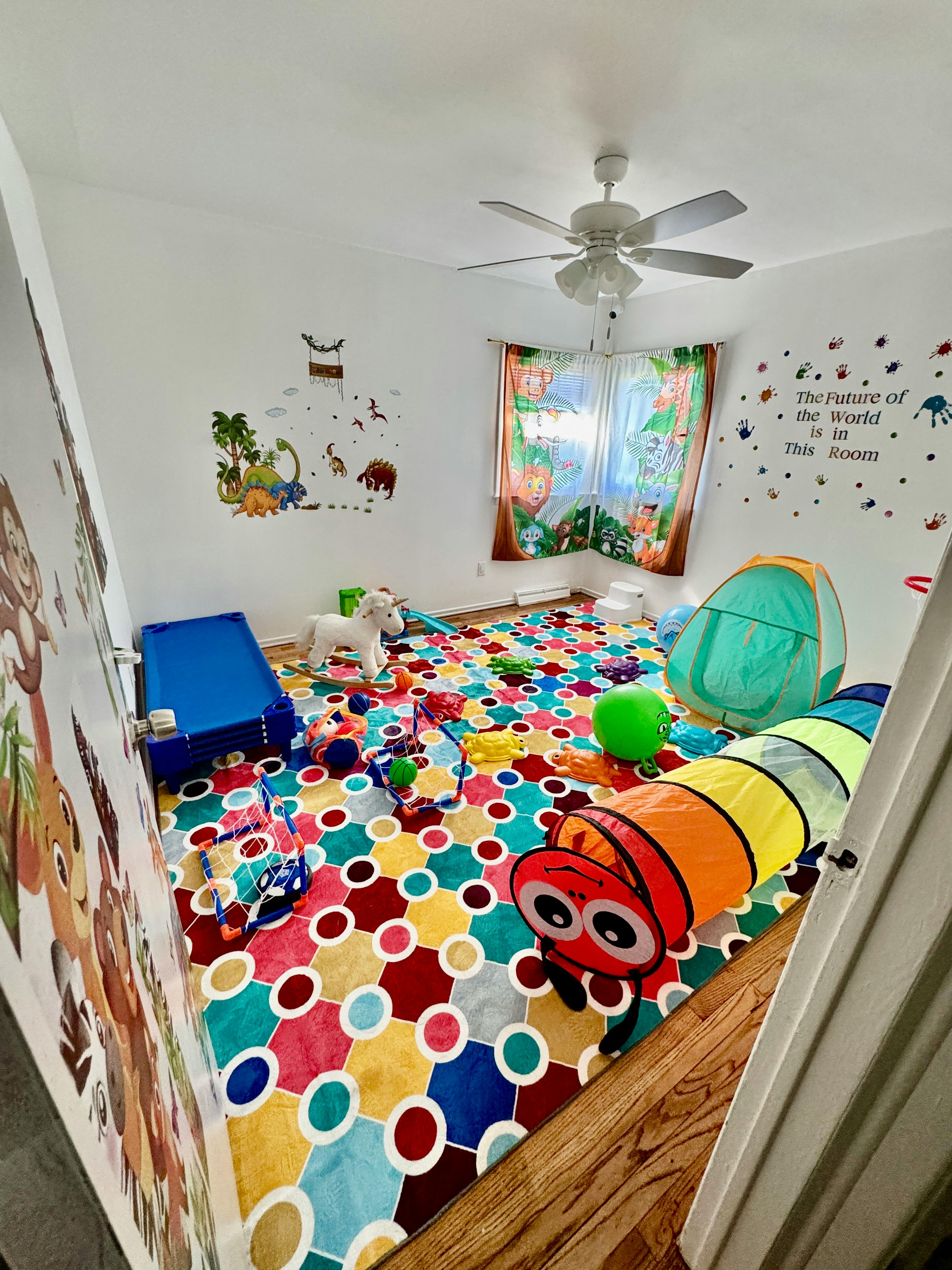 Playroom with colorful rug, toys, and wall decals
