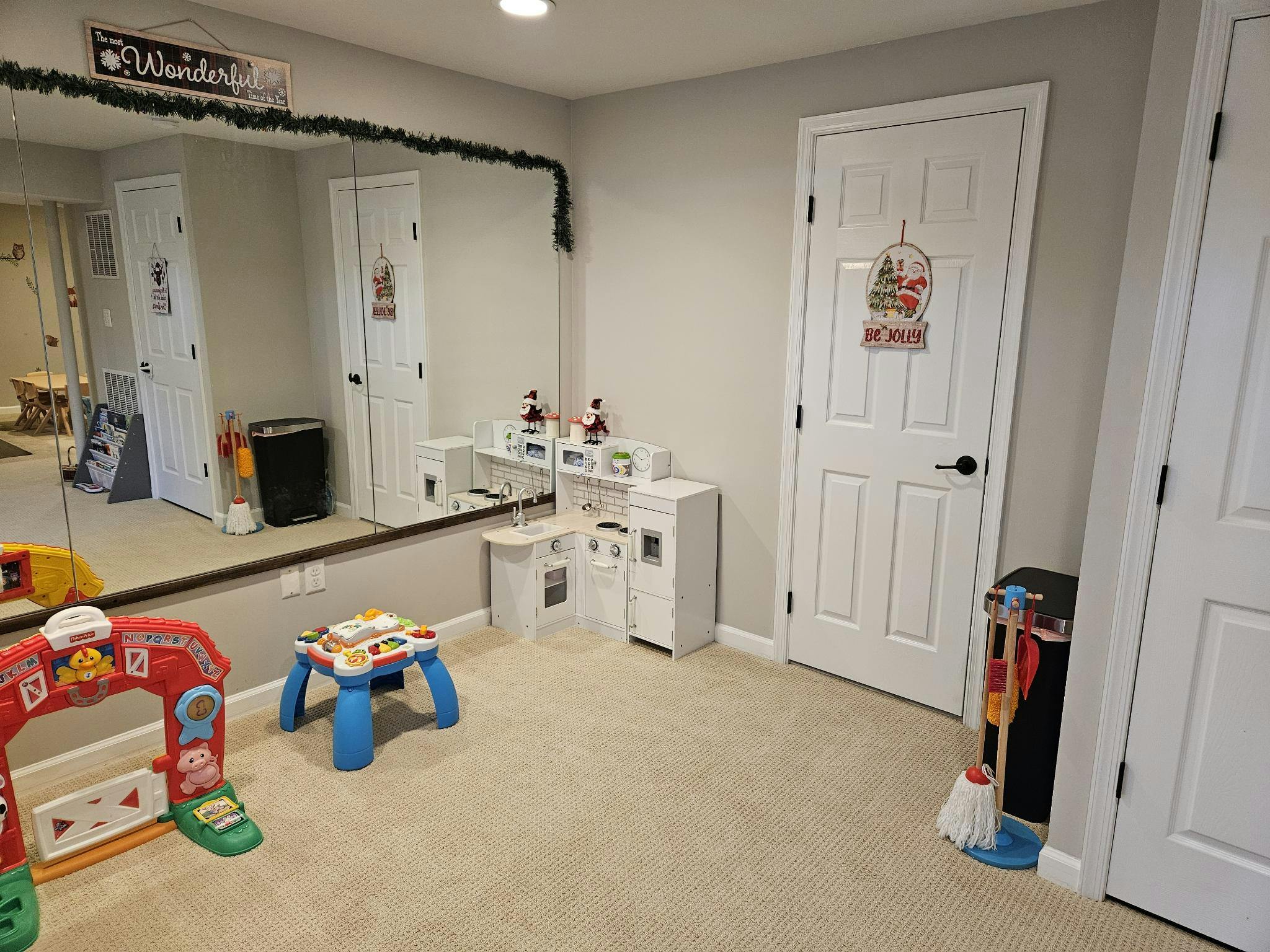 Playroom with a toy kitchen, farm-themed toy, and activity table