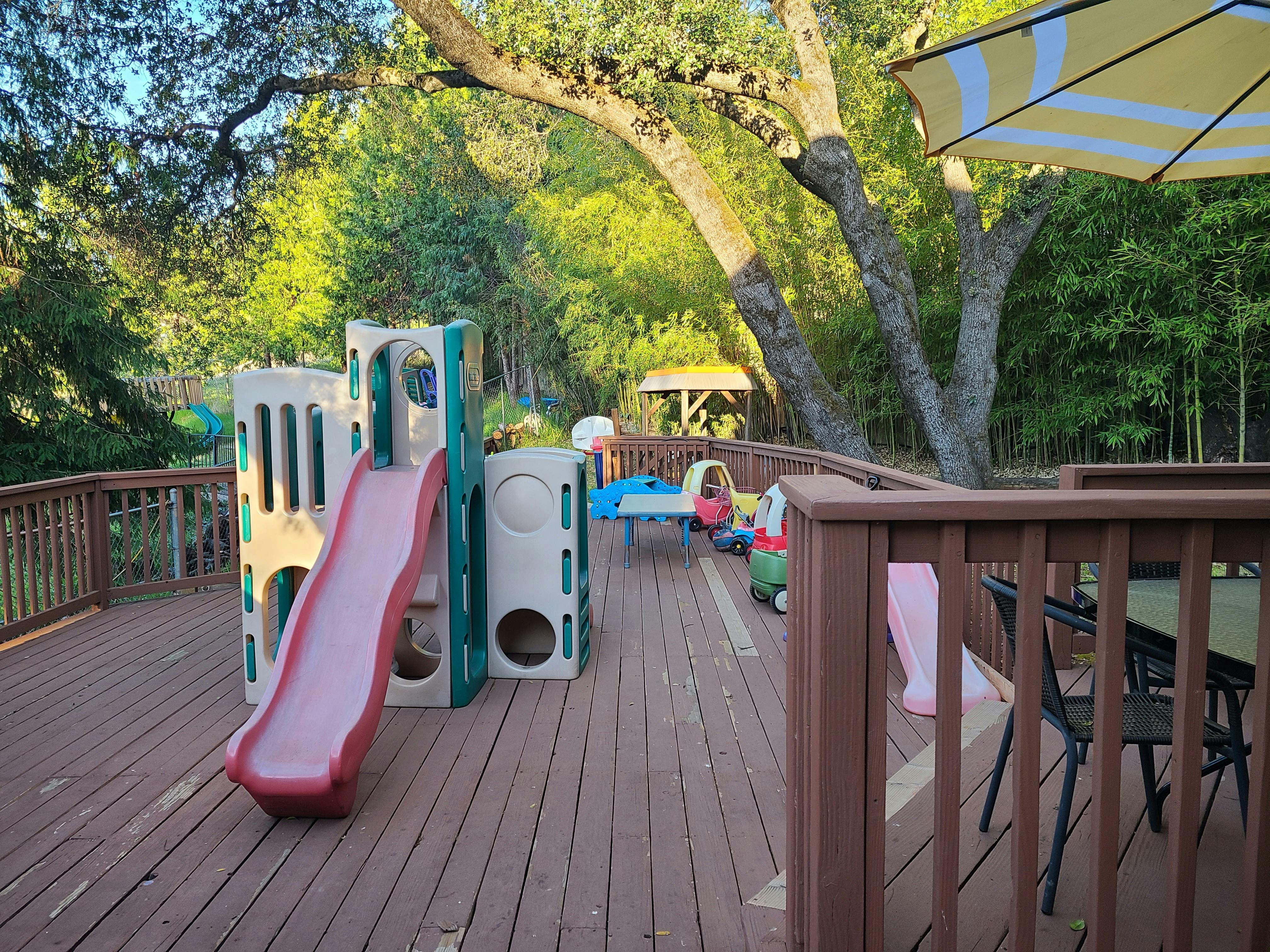 Outdoor deck with a child's playset and slide