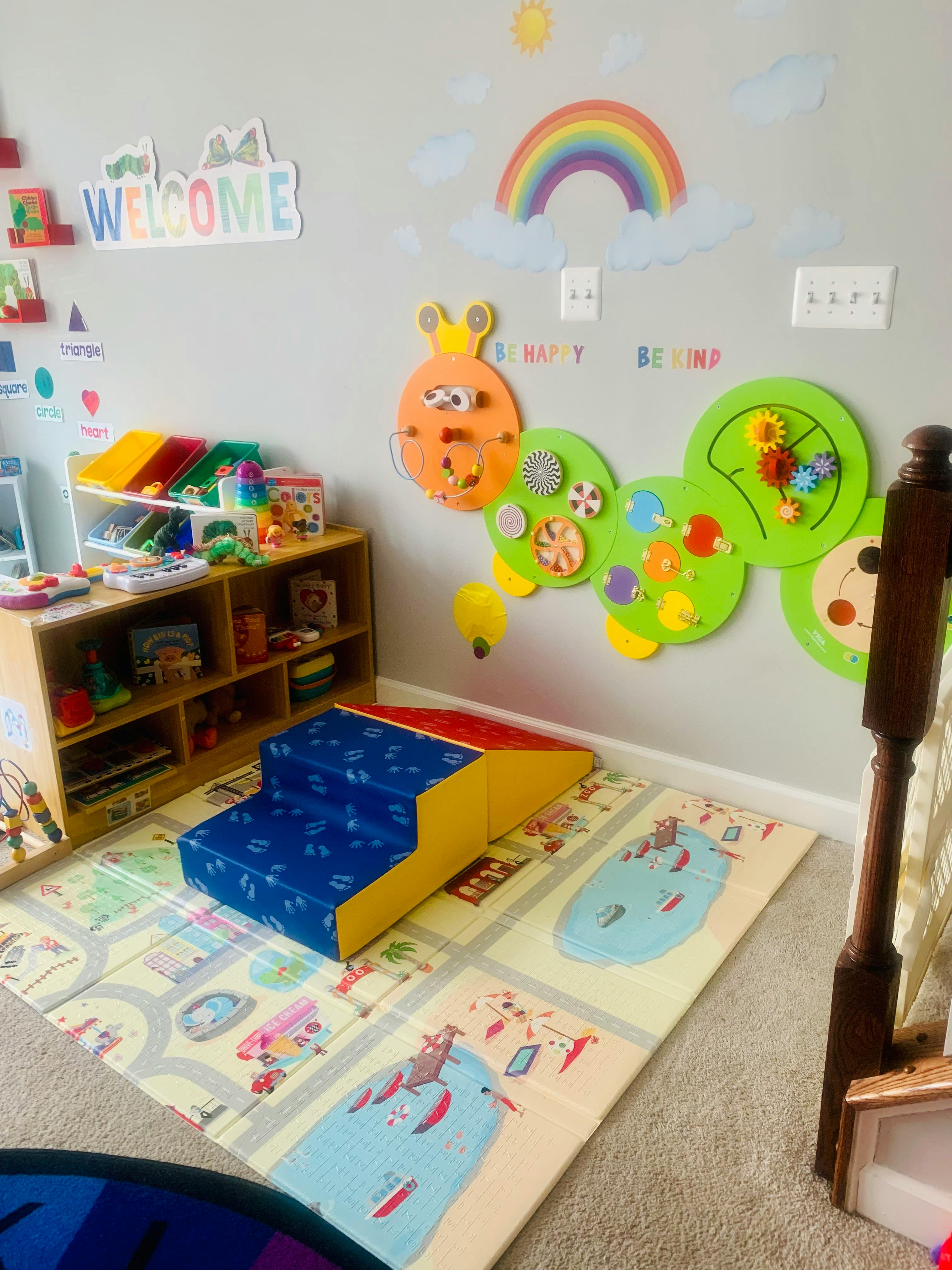 Playroom with soft play steps, toy shelf, and wall decorations
