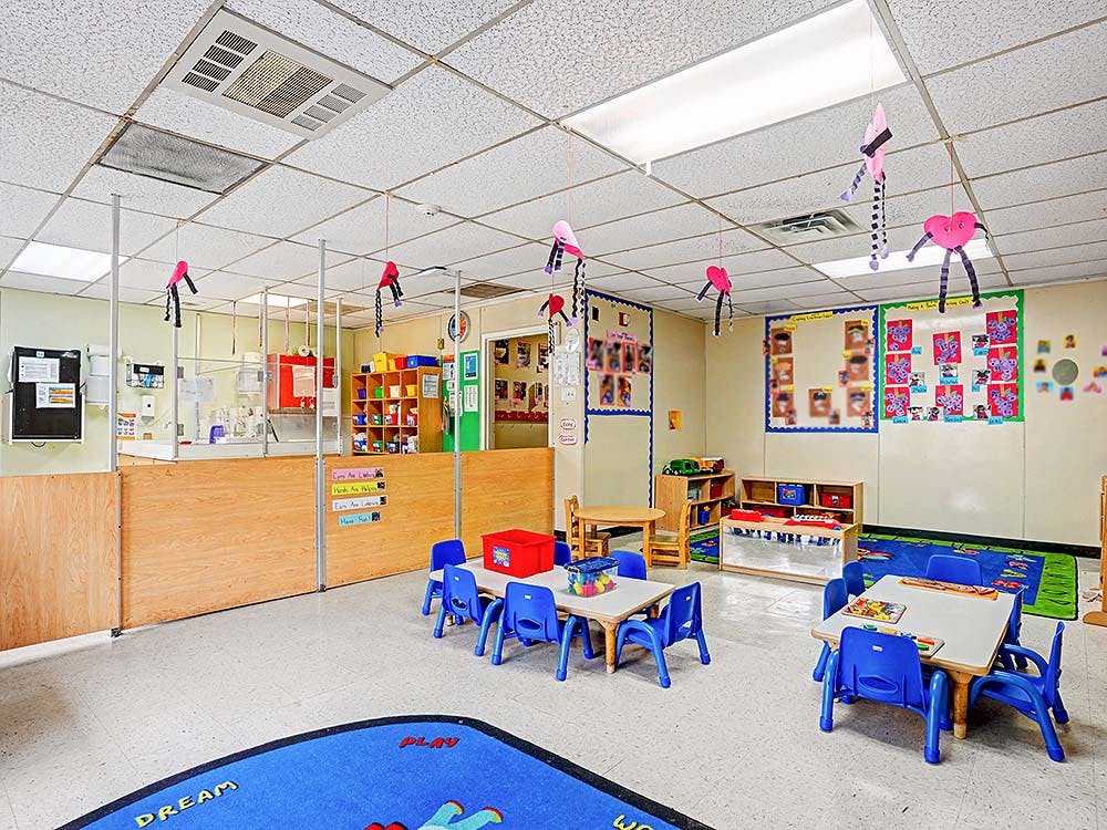 Empty colorful children's classroom with small tables and chairs