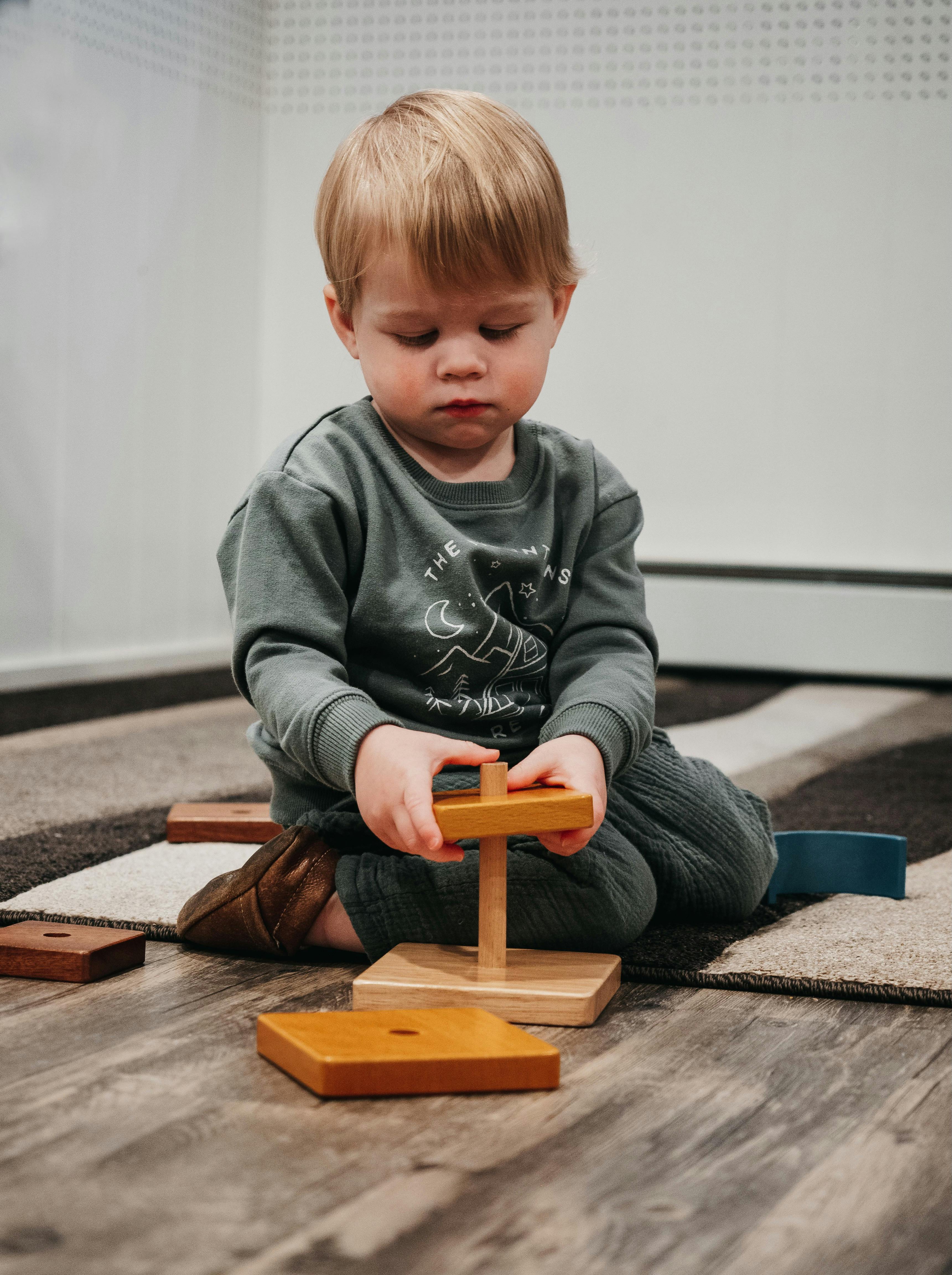 Child playing with a wooden stacking toy