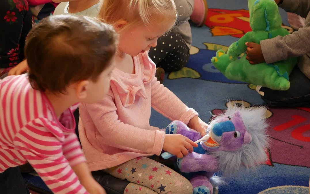 Child playing with a purple stuffed animal