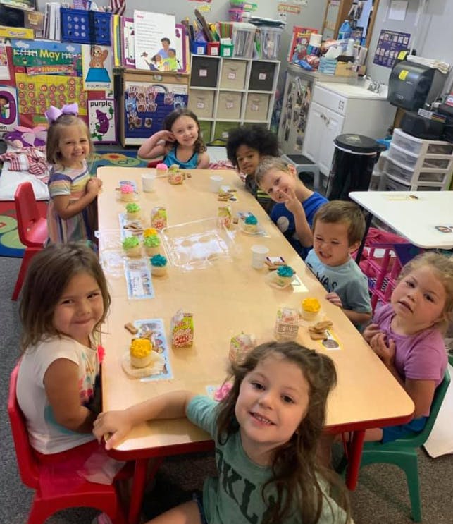 Children sitting around a table with craft supplies