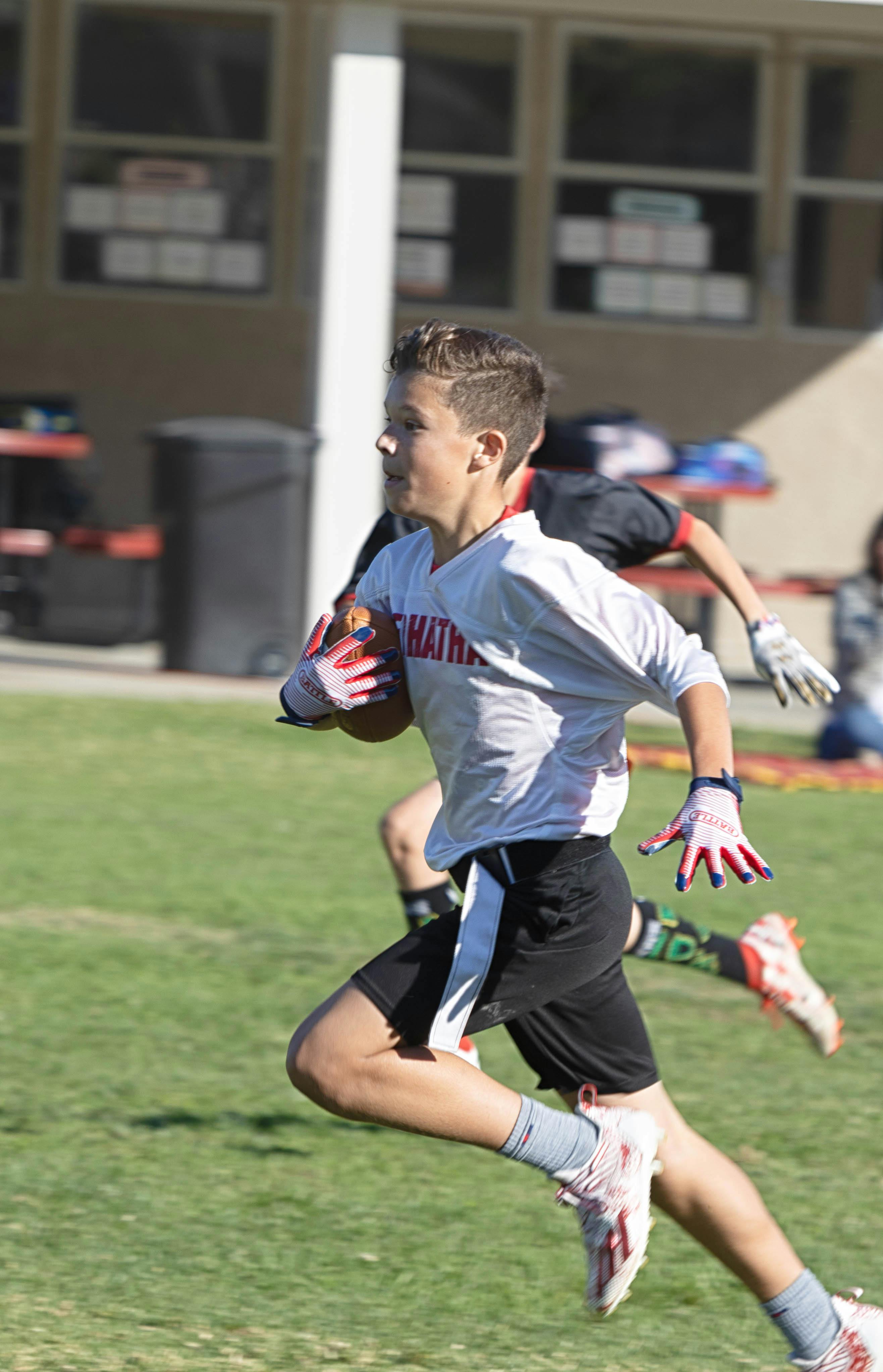 Child running with a football during a game