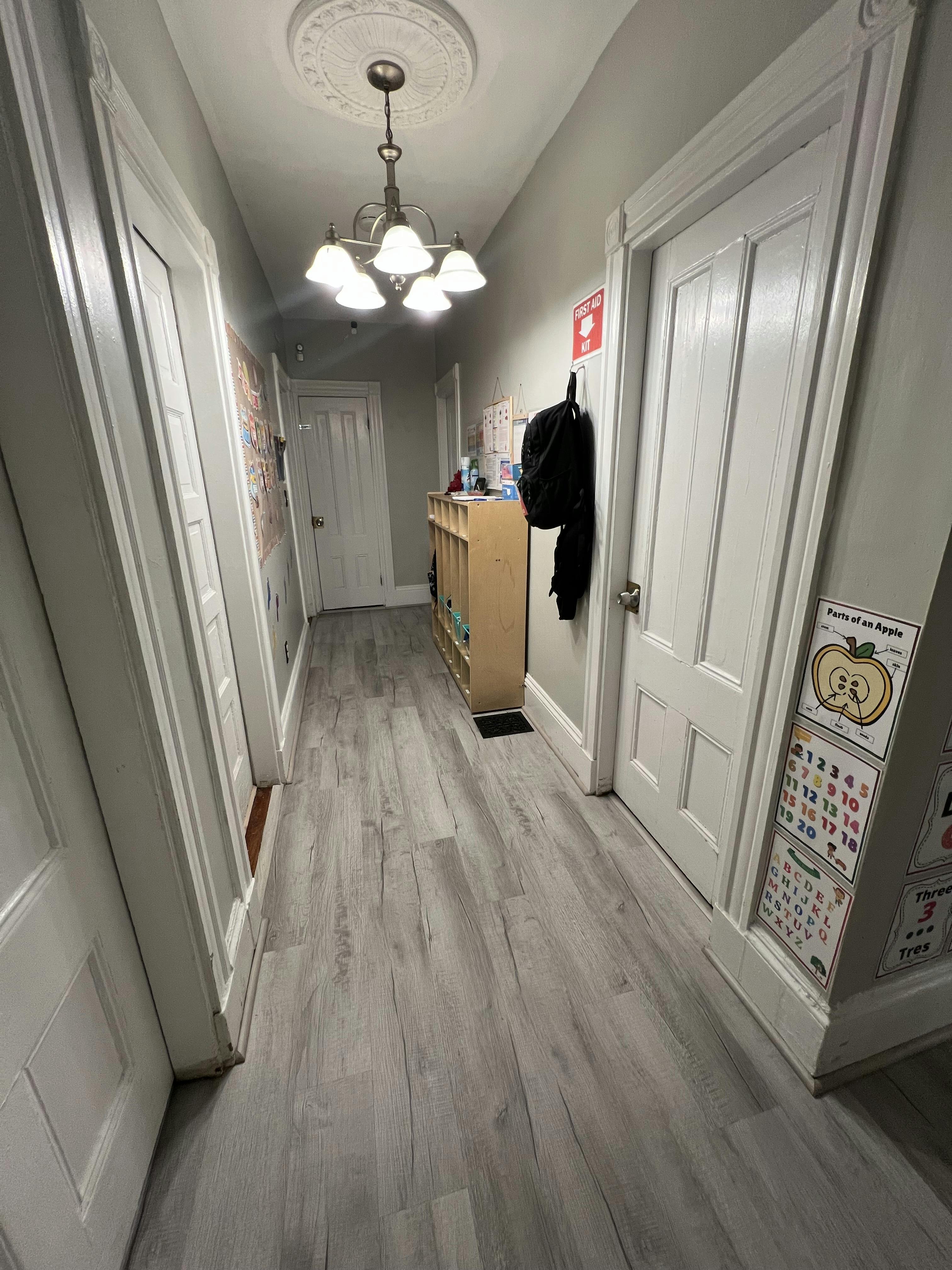 Hallway with light gray flooring and white doors