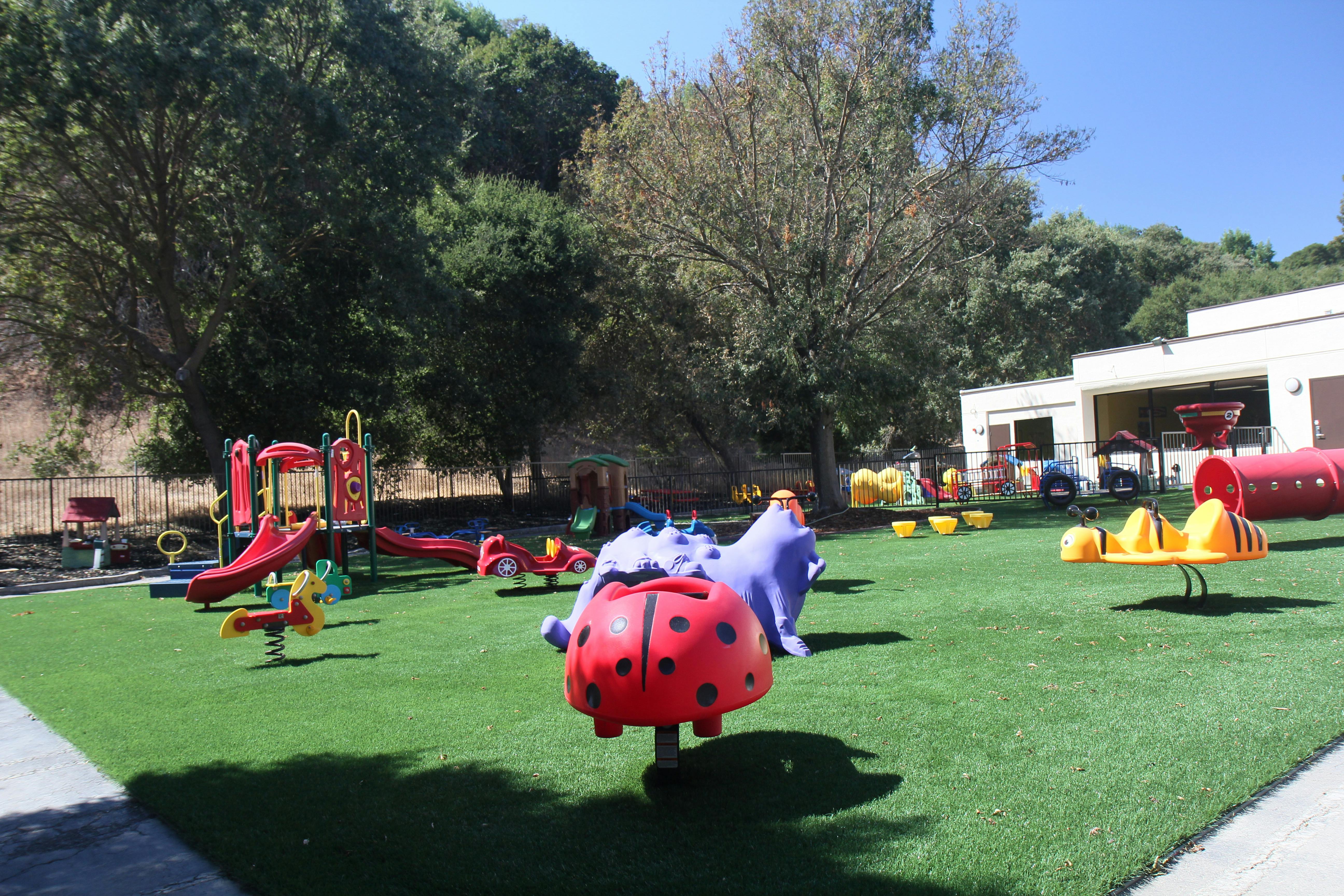 Playground with slides, tunnels, and spring riders on artificial turf