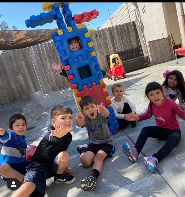 Children playing outdoors with a large colorful block structure