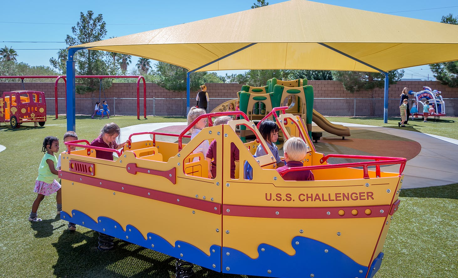 Children playing on a yellow boat structure on a playground