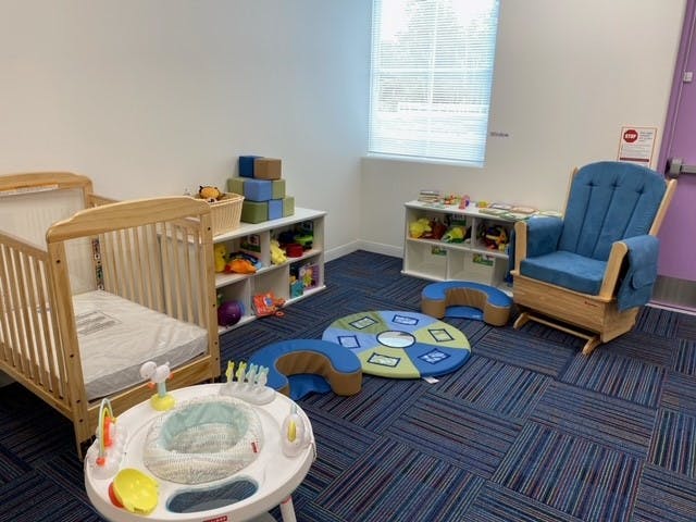 Nursery room with a crib, rocking chair, and play mats