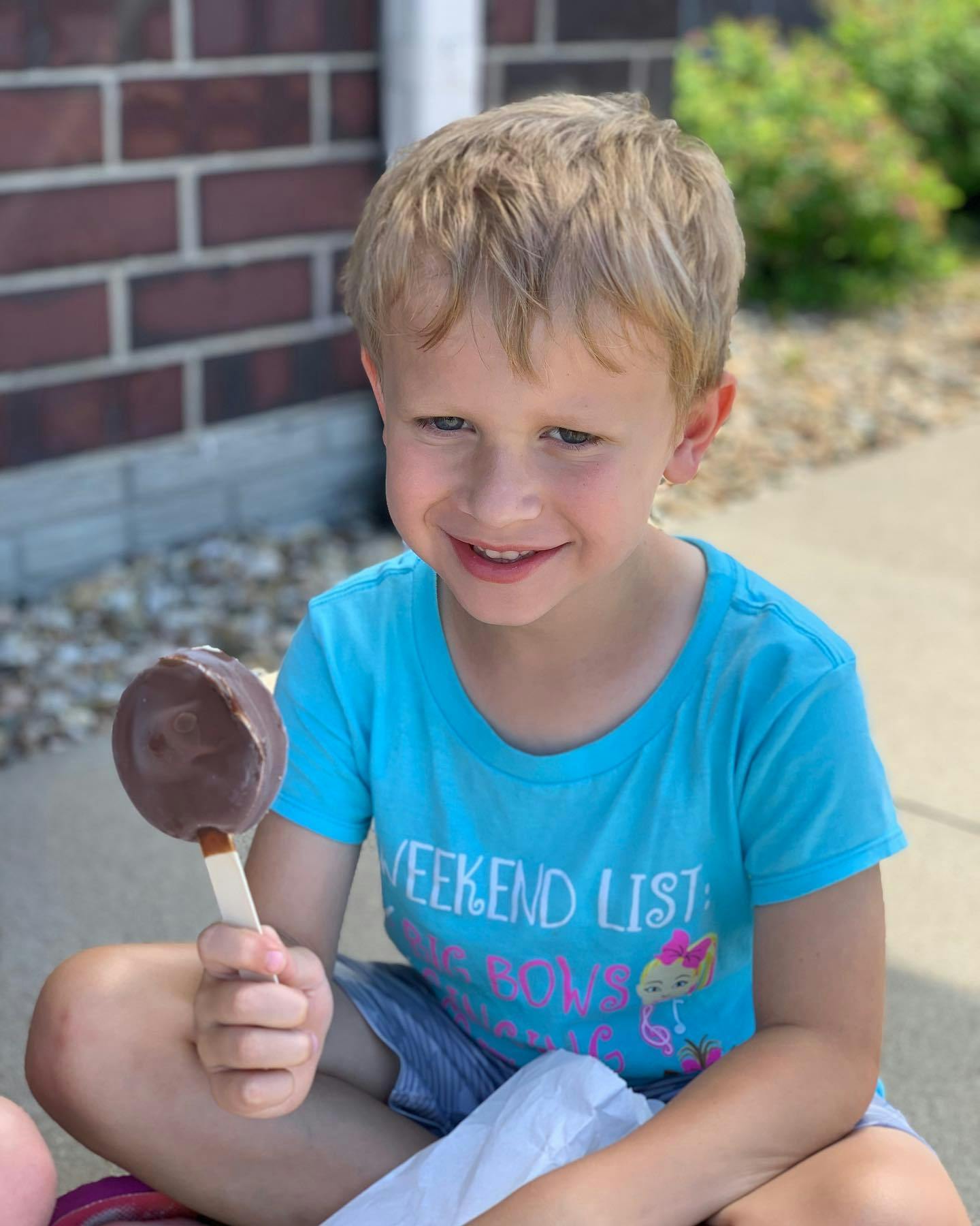 Child holding a chocolate-covered ice cream bar