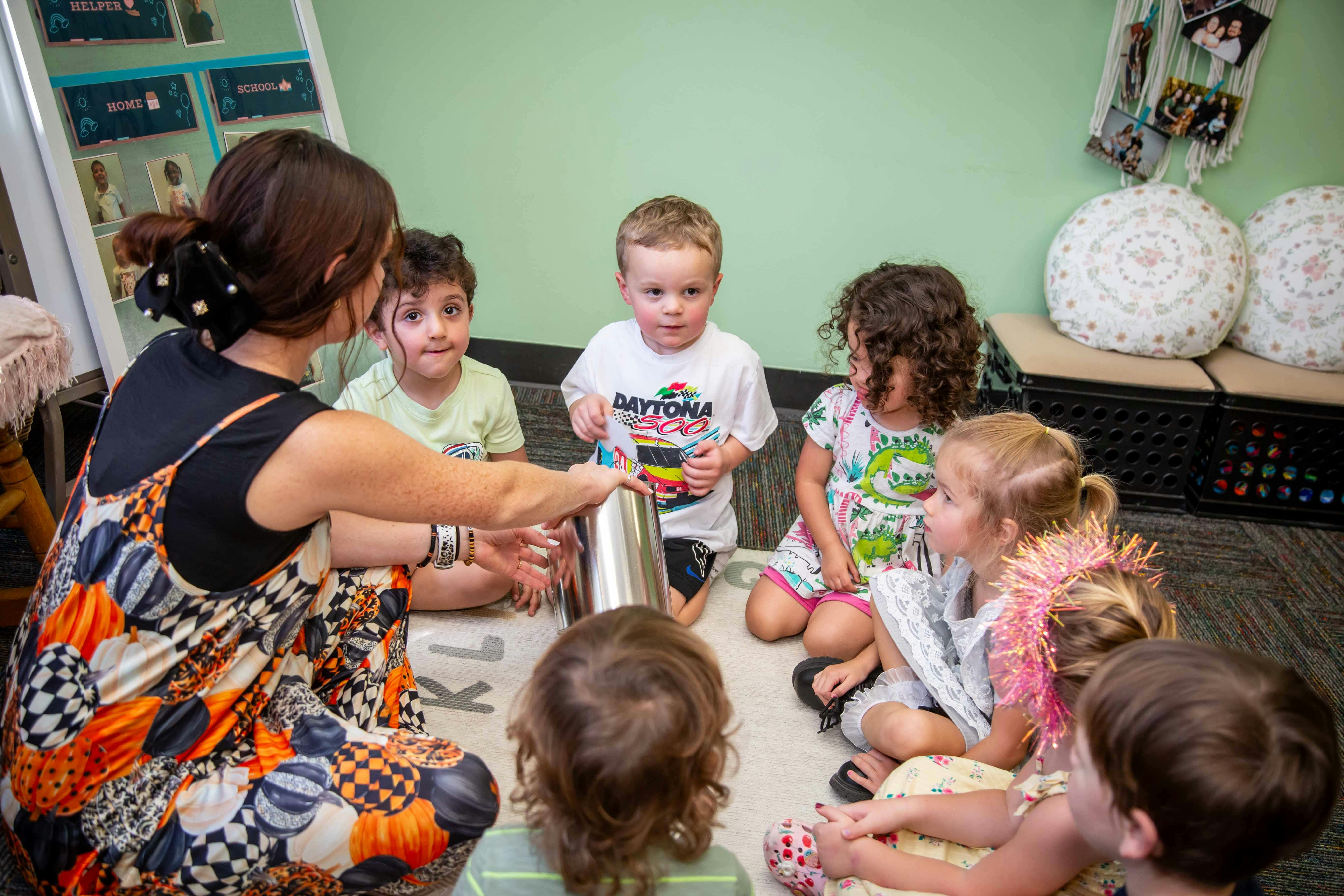 Adult and children sitting on floor in a circle