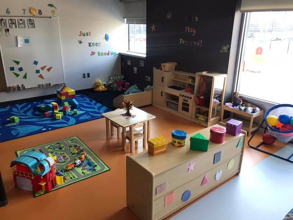 Classroom with play kitchen, small table and chairs, and building blocks
