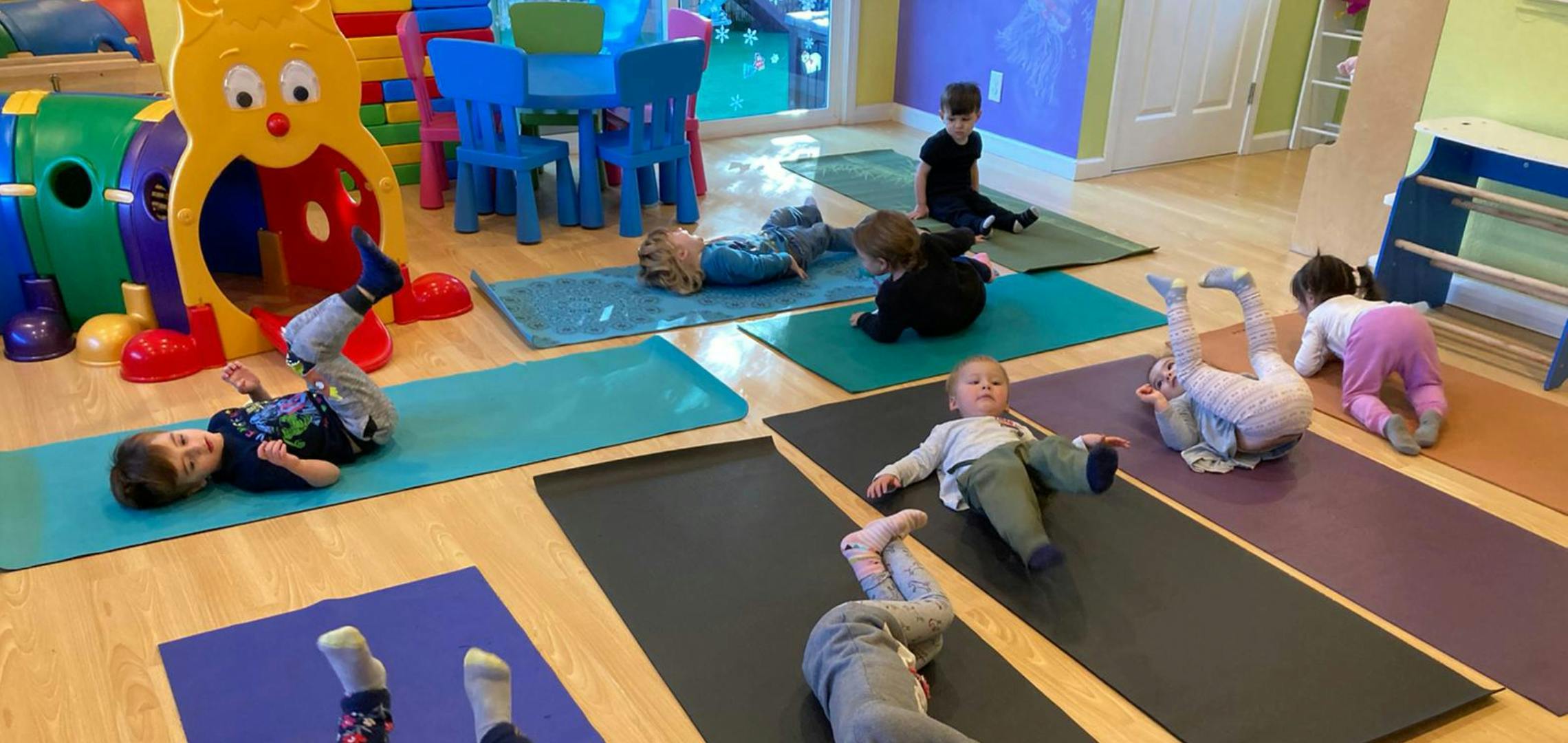 Children practicing yoga on colorful mats in a playroom