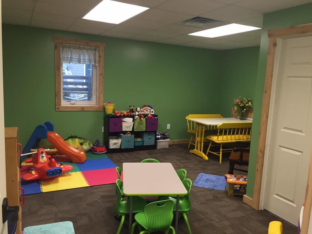 Playroom with small tables and chairs, toy storage, and a slide