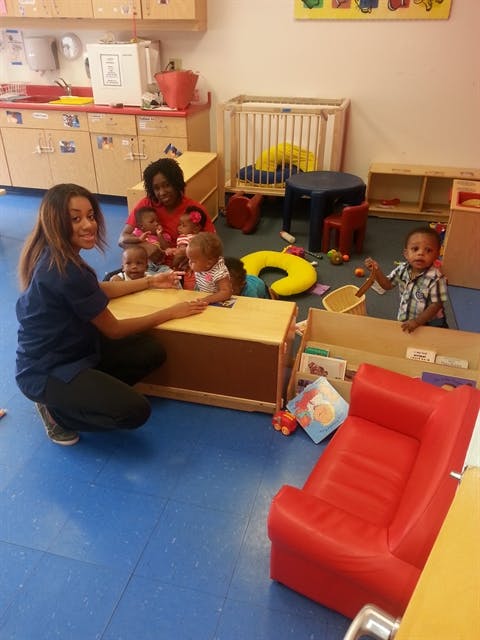 Two people with multiple children in a classroom