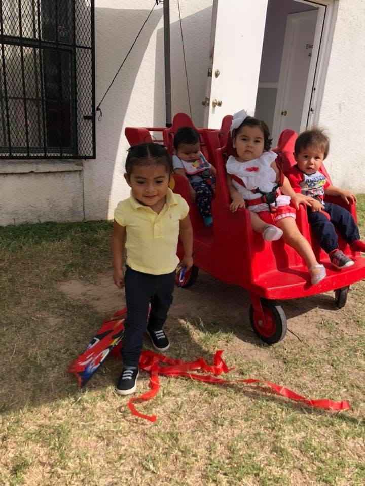 Four children with a red wagon
