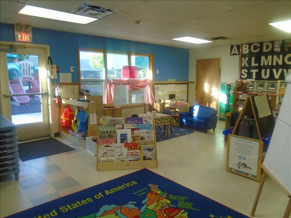 Classroom with children's books, toys, and a "United States of America" rug